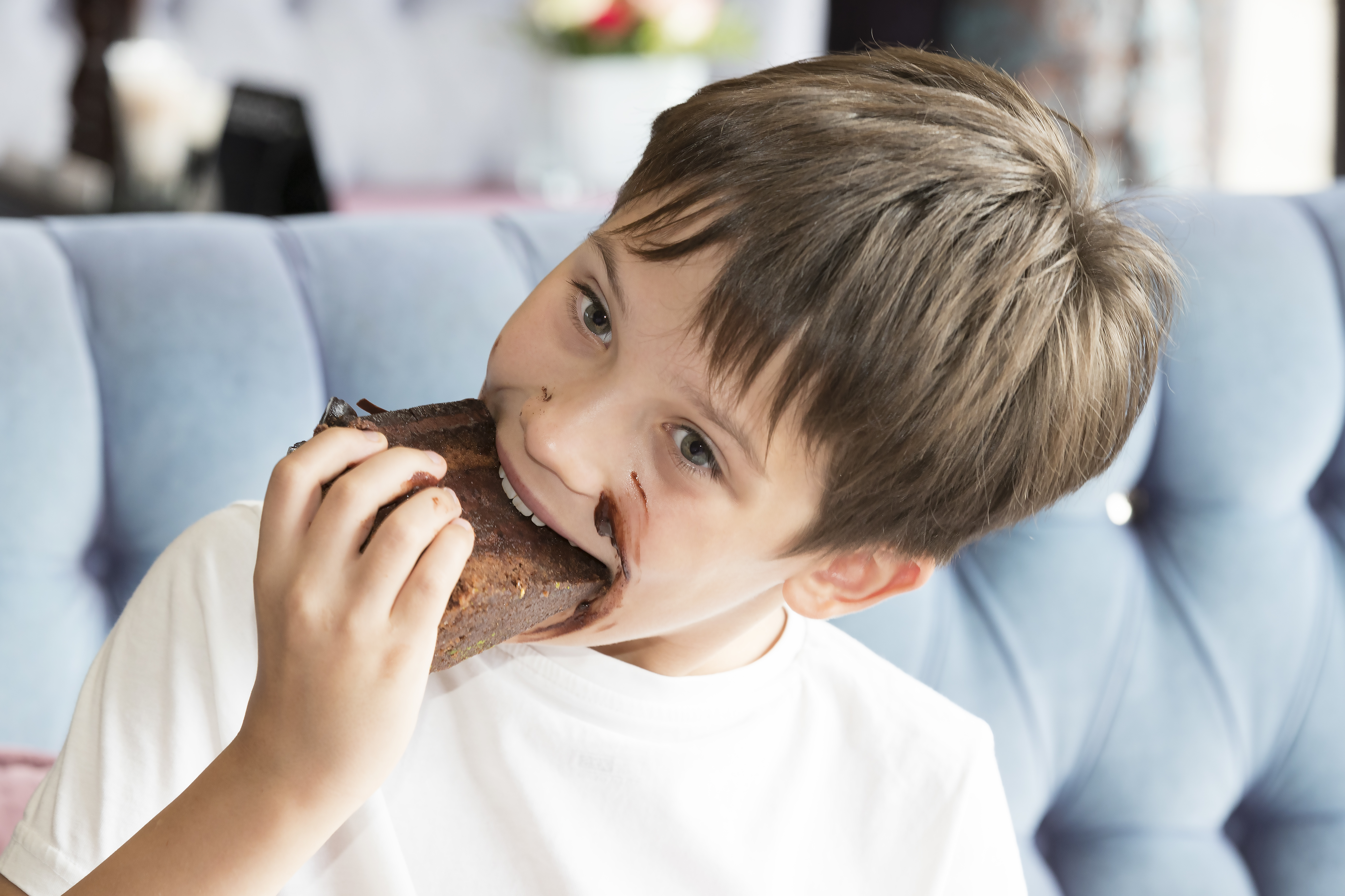 Smiling boy eating a piece of choclate cake